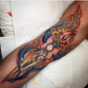 Color ink arm tattoo of a flaming bejeweled Buddhist vajra dagger by Natan Alexander.
