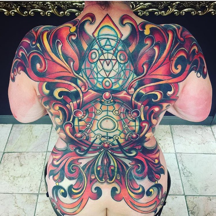 Full back color ink tattoo of wings comprised of scroll design with alchemical sacred geometry at center by Natan Alexander.