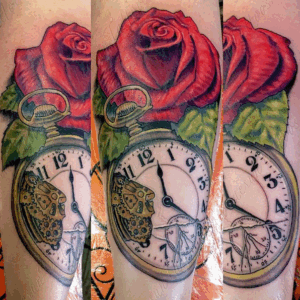Realistic tattoo in color ink of red roses and a broken pocket watch clock by Jaesun Duggan