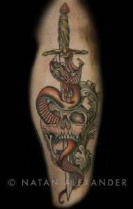 Leg tattoo in color ink of traditional skull with snake and dagger going through it by Natan Alexander.