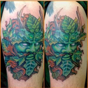 Arm tattoo in color ink of a leafy Green Man with horns by Jaesun Duggan